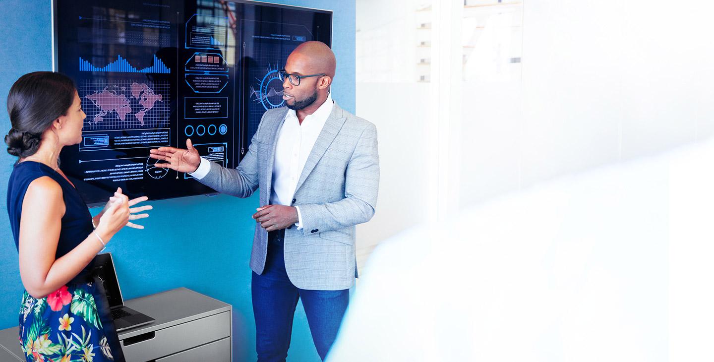 Man in suit talking to a woman in a hawaiian dress about Viasat's enterprise internet solutions